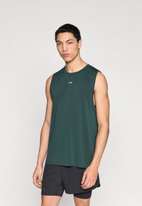 Σκούρο πράσινο αμάνικο αθλητικό πουκάμισο με στρογγυλή λαιμόκοψη και μικρό λογότυπο στο στήθος, σε συνδυασμό με μαύρο σορτς. Λείος υφασμάτινος ιστός.