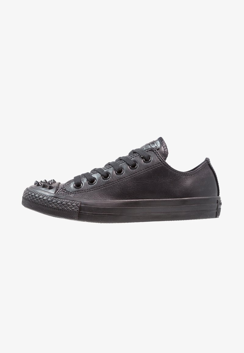 Black leather sneaker with a low profile, round toe, and spiked accents on the toe cap. Features six pairs of eyelets and a textured sole.