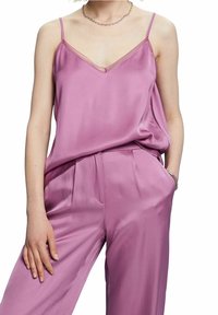 Satin cami och byxor i ljus rosa. Camien har tunna axelremmar och en v-ringning. Byxorna har sidofickor och en avslappnad passform.