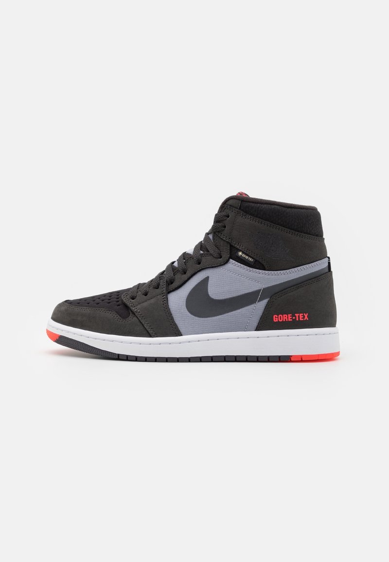 Baskets montantes noires et grises Nike avec virgule noire, étiquette GORE-TEX rouge, semelle intermédiaire blanche et détails rouges sur la semelle.