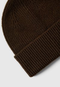 Gorro de punto marrón con textura acanalada y puño doblado, hecho de material suave, con un color uniforme en toda su superficie.