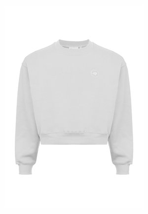Lichtgrijze cropped sweatshirt met een geribde ronde hals en lange mouwen, met een klein rond wit logo op de borst. Zachte textuur.