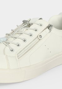 Baskets blanches avec lacets élastiques, verrou métallique pour lacets et fermeture éclair latérale sur dessus en cuir lisse et semelle en caoutchouc.