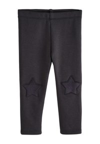 Leggings negras de tela suave, con dos apliques de estrellas oscuras en las rodillas. La cintura es elástica y las costuras están reforzadas.