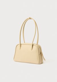 Μπεζ δερμάτινη τσάντα χειρός με δύο λείες λαβές, ορθογώνιο σχήμα, χρυσή λεπτομέρεια φερμουάρ και διακριτική υφή στο τελείωμα.