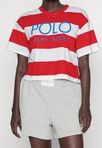 Randig kortärmad t-shirt i röd och vit med blå "POLO"-text. Matchad med grå bomullsshorts med elastisk midja och logotag.