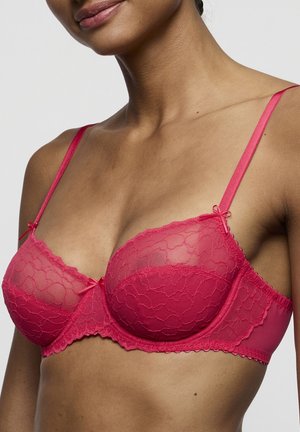 Rood kanten beugelbh met doorschijnende mesh cups, geschulpte randen en verstelbare bandjes. Decoratieve strikjes op de bandjes voegen detail toe.