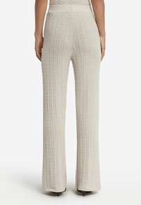 Lichtbeige kabelgebreide broek met een wijdpex ontwerp, textuurstof en een hoge tailleband, met ribbeldetails langs de benen.