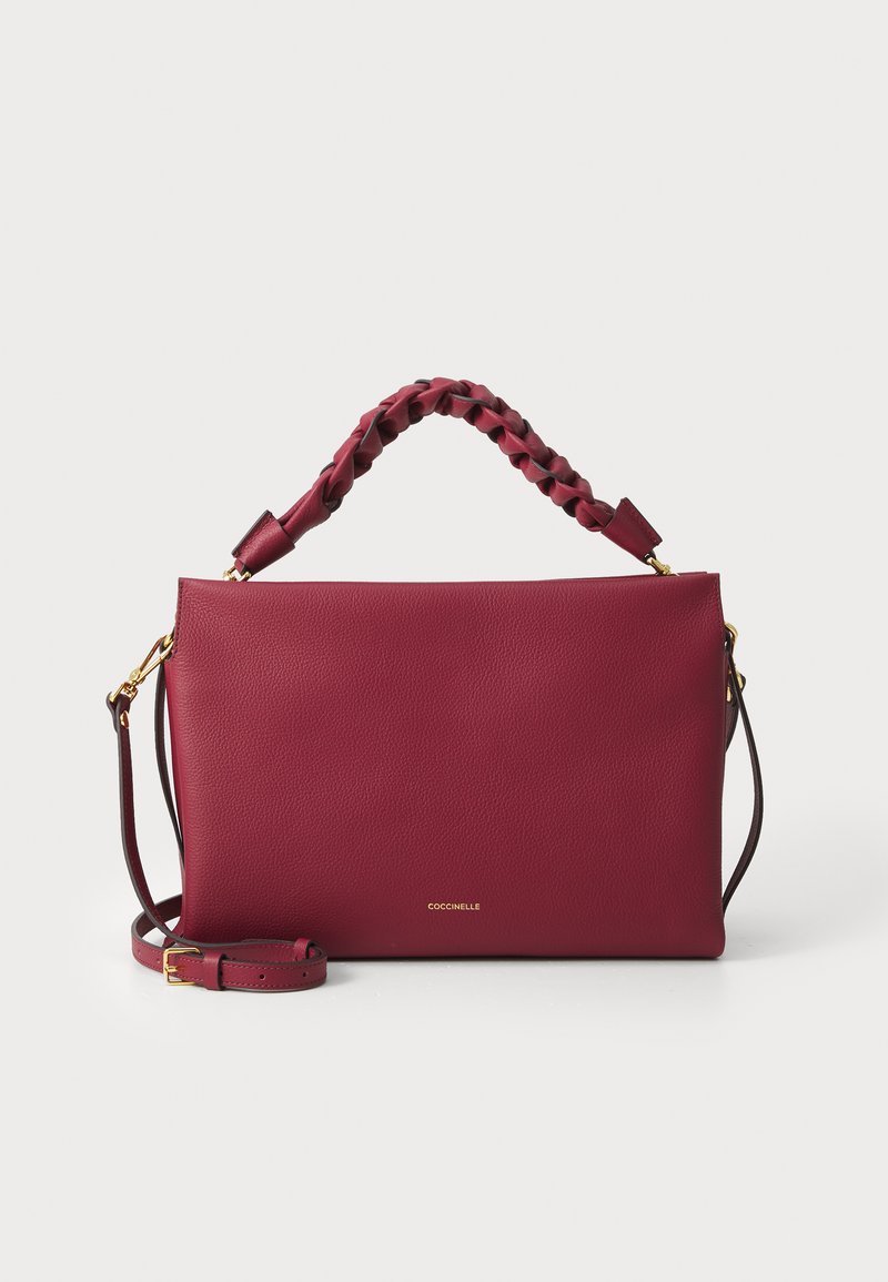 Bordeaux læder taske med en flettet topstrop, justerbar rem og gulddetaljer. Har en glat tekstur og minimalistisk design.