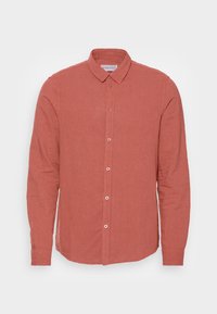 Camisa de manga larga con cuello en un suave tono terracota apagado, con botones en la parte delantera y fabricada en tejido de lino texturizado.