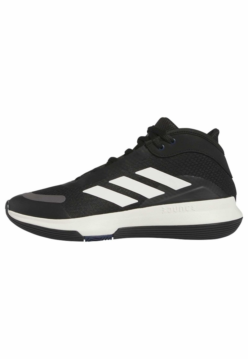 Zwarte sport schoen met een mid-top ontwerp, voorzien van een gestructureerde mesh bovenkant, drie witte strepen en een rubberen buitenzool voor grip.