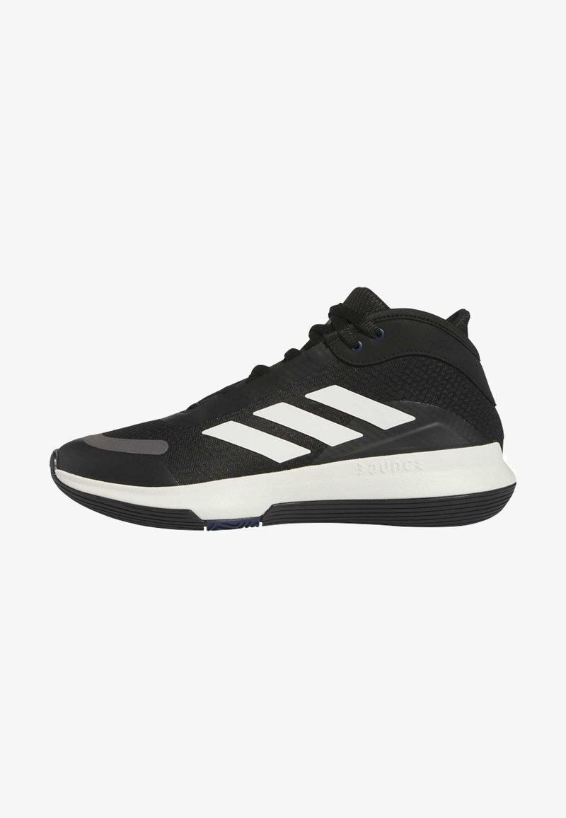Zwarte sport schoen met een mid-top ontwerp, voorzien van een gestructureerde mesh bovenkant, drie witte strepen en een rubberen buitenzool voor grip.