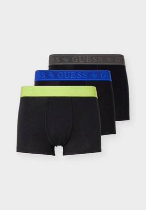Kolm musta bokserit, millel on laiad elastsed vöökohad laimirohelises, sinises ja tumedas hallis toonis, igaühel on bränditud "GUESS" tekstiga.