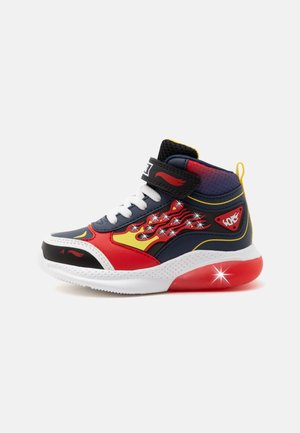 Baskets montantes pour enfants avec un motif de flammes rouges, jaunes et bleu marine, lacets blancs et semelle rouge lumineuse sur fond blanc.