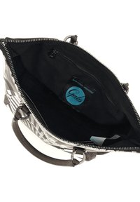 Sac à main en cuir avec un extérieur à motifs géométriques gris et blancs. L'intérieur comprend une doublure noire avec une poche zippée et une étiquette de marque.