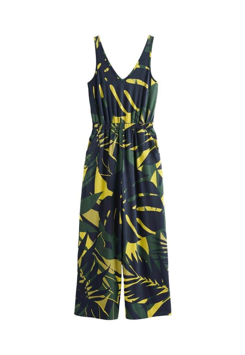Combinaison sans manches avec un profond décolleté en V et des jambes larges, ornée d'un motif de feuilles tropicales vertes et jaunes sur un fond sombre.