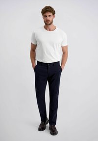 Weißes kurzärmliges T-Shirt, marineblaue Hose und dunkle Schuhe. Die Hose hat einen Knopfverschluss und Taschen, einen glatten Stoff und einen geraden Schnitt.