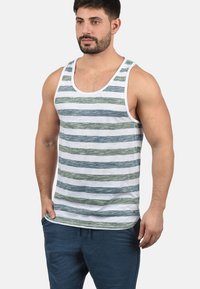 Stripet tanktopp i hvit, grønn og blå, med rund utringning og brede skulderstropper. Myk stoff med en avslappet passform.