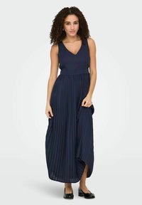 Navy blue pleated maxi dress with a V-neck and sleeveless design, featuring a fitted bodice and flowing, textured skirt.