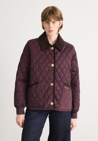 Gequilted bordeauxjack met een bruine corduroy kraag, gouden drukknoopjes en zijzakken met een merketiket. Effen kleur met ruitpatroon.