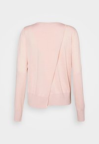 Jasnoróżowy sweter z długimi rękawami, okrągłym dekoltem i asymetrycznym wzorem z tyłu, z rozcięciem na dole.