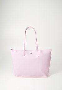 Różowa torba na ramię o gładkiej fakturze, z dwiema długimi rączkami i zapięciem na zamek. Charakteryzuje się minimalistycznym wzornictwem oraz niewielkim logo marki umieszczonym na przedniej części.