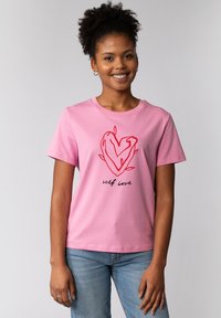Rosa Baumwoll-T-Shirt mit einem roten Herzdesign und Blättern sowie dem Text "Selbstliebe" in Schwarz. Kurze Ärmel und runder Ausschnitt.