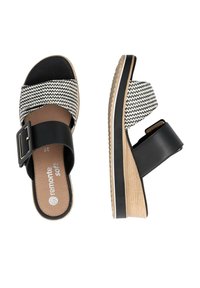 Schwarz-weiße Wedge-Sandalen mit einem strukturierten, gestreiften Obermaterial, einem schwarzen Riemen und Schnalle sowie einer leichten Plattformsohle im Holzstil.