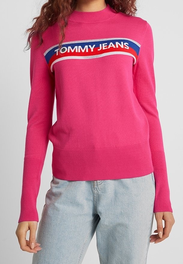Fuchsia Pullover aus Strickstoff mit hohem Halsausschnitt, gerippten Bündchen und einem horizontalen Logodesign in Blau, Rot und Weiß über der Brust.