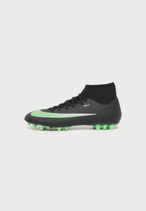 Sort og grøn fodboldstøvle med grønne knopper, høj ankelstrømpe-design og stor grøn Nike-swoosh på siden.