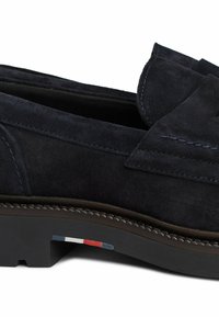 Granatowe zamszowe mokasyny z akcentowanym przeszyciem, okrągłym noskiem i gumową podeszwą, z detalem w postaci flagi w kolorach czerwonym, białym i niebieskim po boku.