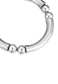 Segmento de una pulsera de plata brillante que presenta barras curvadas y cuentas esféricas lisas sobre un fondo blanco.