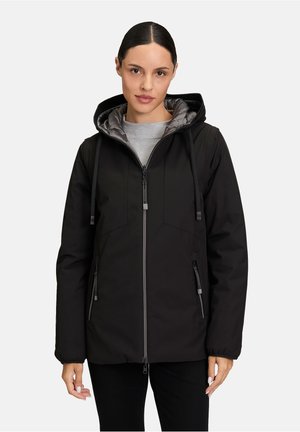 Giacca nera isolata con cappuccio, dotata di fodera trapuntata grigia, tasche con zip e coulisse regolabili. Texture liscia e opaca.