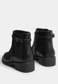 Svarta läderankelstövlar med dragkedja i sidan, elastiska paneler och spänne. Rundad tå och låg klackdesign.