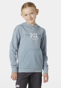 Sudadera azul clara con capucha y bolsillo delantero. Presenta un estampado de logo blanco y puños de canalé. El material parece suave y ligero.