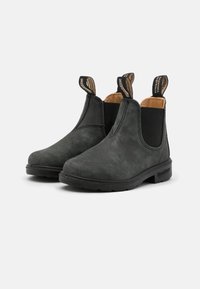 Botas Chelsea negras de cuero texturizado, con paneles laterales elásticos y lengüetas de tirón, y una suela de goma resistente para mayor durabilidad.