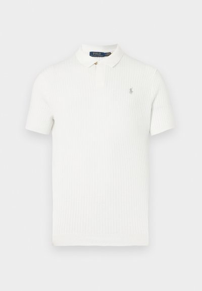 Biele rebrované polo tričko so skladacím golierom a krátkymi rukávmi. Na ľavej strane hrude má malú vyšívanú značku. Mäkká textúra látky.