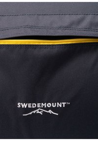 Sort stof med en glat tekstur, udstyret med en gul lynlås og et hvidt broderet logo "SWEDEMOUNT" med bjerg kontur.