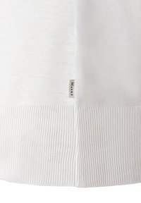 Weißer Strickpullover mit glatter Textur und geripptem Saum. Verfügt über ein kleines Etikett mit der Aufschrift "MAERZI" an der Seite.