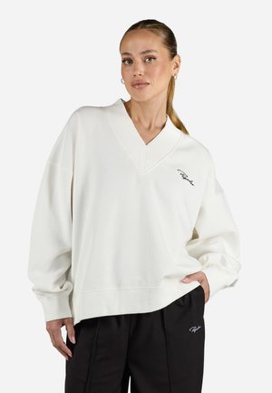 White oversized sweatshirt with a deep V-neck, ribbed cuffs, and a small embroidered logo. Soft cotton texture, relaxed fit.