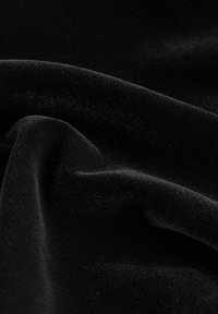 Material din catifea neagră, cu o textură netedă și moale, având un luciu subtil și pliseuri delicate, evidențiind bogăția și adâncimea culorii.