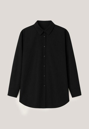 Črna dolgoplesna srajca z gumbi in ovratnikom, ravnim robom ter gumbnimi manšetami, razprostrta na svetli podlagi.