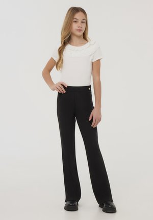 Top bianco a maniche corte con scollo arricciato, abbinato a pantaloni neri a vita alta svasati con cucitura frontale e dettaglio con bottone dorato.