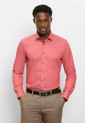 Roze overhemd met lange mouwen, een puntkraag, knoopsluiting aan de voorkant en een gladde textuur, gedragen met bruine broek met structuur en een bruine riem.