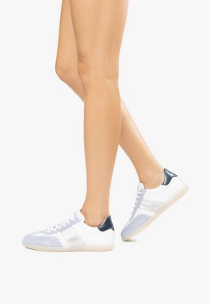 White sneakers with light blue suede accents, silver stripes, and a dark blue heel. Rubber sole, lace-up design, and smooth texture.