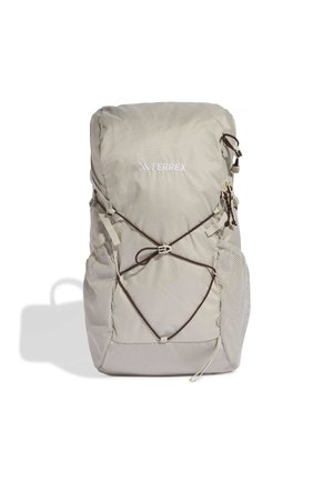 Jasno beżowy plecak turystyczny z przednim elastycznym sznurkiem, bocznymi kieszeniami z siatki, regulowanymi paskami oraz logo "TERREX" na przednim środku.