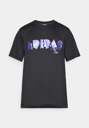 Svart t-shirt med en stor, flerfärgad grafisk tryck med texten "ADIDAS" och silhuetter. Krot ärmsdesign, rund hals.