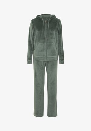 Mályvaruházat tompa zöld színben, cipzáras kapucnis pulóverrel, húzózsinórokkal és elülső zsebekkel, egyenes szárú nadrággal párosítva.