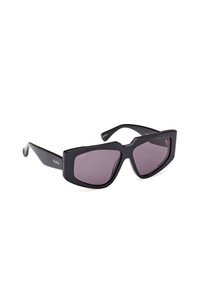Black sunglasses with a bold geometric design, featuring dark lenses and a matte finish. The frames have a distinctive angular shape.