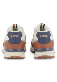 Tênis atléticos marrons e bege com um upper em malha texturizada e couro, apresentando um detalhe em azul-marinho e uma sola robusta em bege. Logotipo da BOSS no calcanhar.